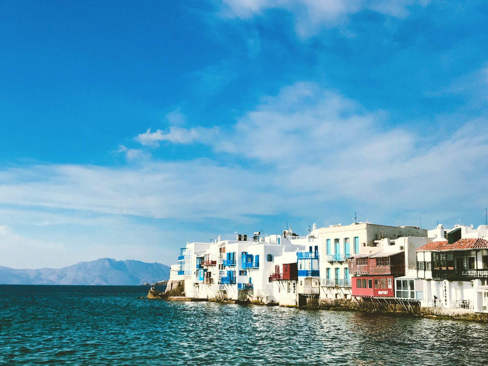 white concrete houses near body of water