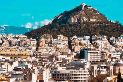 city buildings near mountain under blue sky during daytime