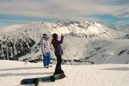 man and woman standing on snow covered ground during daytime