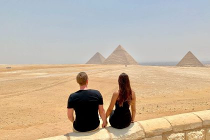 man and woman sitting on concrete wall during daytime
