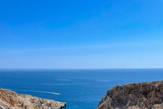 aerial view of green and brown mountain beside blue sea during daytime