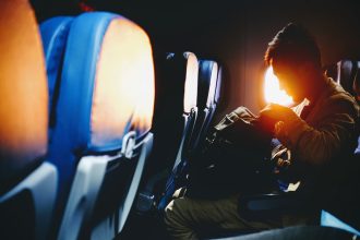 man looking on his sitting on plane seat