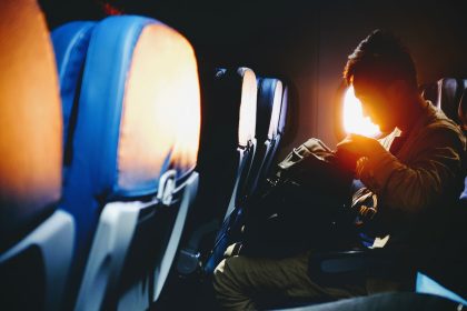 man looking on his sitting on plane seat