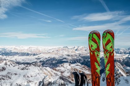 person in black pants and blue snow ski blades standing on snow covered mountain during daytime