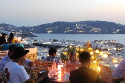 people sitting on chair in front of table with candles on top of it during night