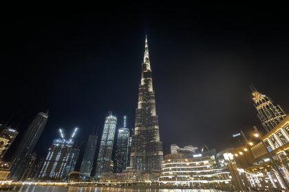 a very tall building towering over a city at night