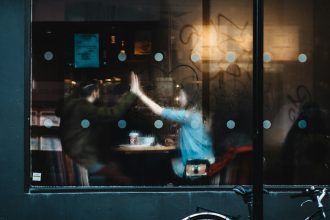 man and woman clapping each other hands inside the cafe
