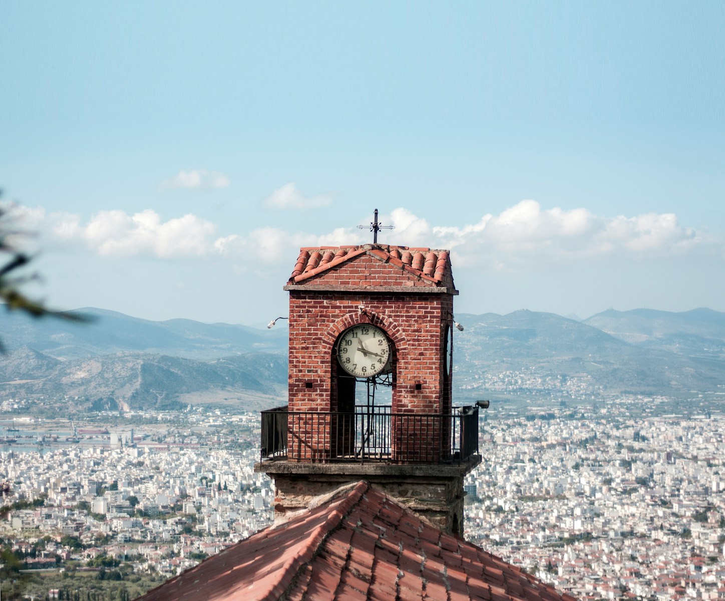 a clock tower on top of a building with a city in the background