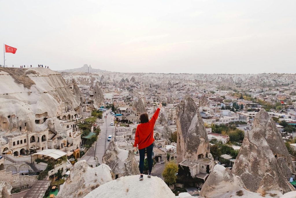 Person Wearing Red Long-sleeved Shirt Standing on Rock