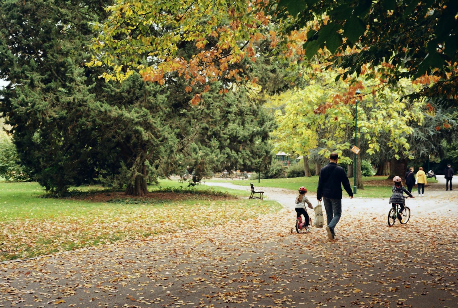 A family enjoys a bike ride through a scenic park in Nancy during fall.