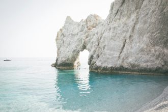 brown rock formation on blue water during daytime