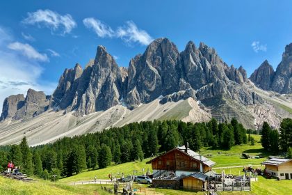 a mountain range with a small cabin in the foreground