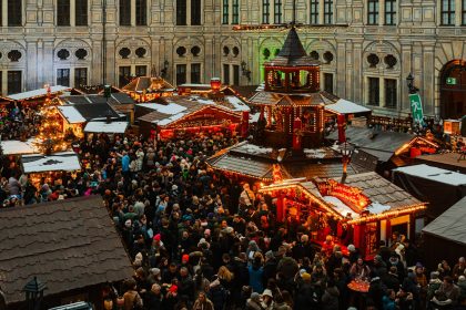 A crowd of people standing around a christmas market
