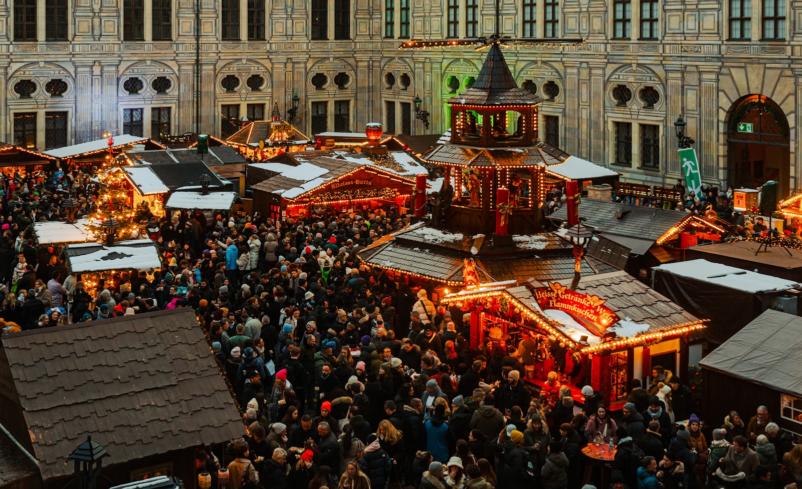 A crowd of people standing around a christmas market
