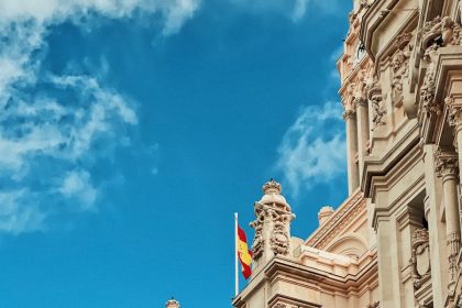 yellow and red flag hanging on white building